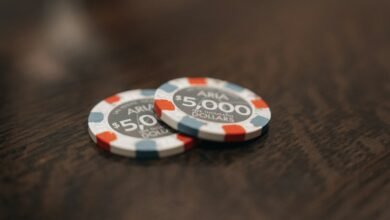 two poker chips sitting on top of a wooden table